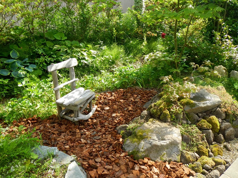 イチゴ畑の前にいすを置き、木蔭と木漏れ日を楽しむ