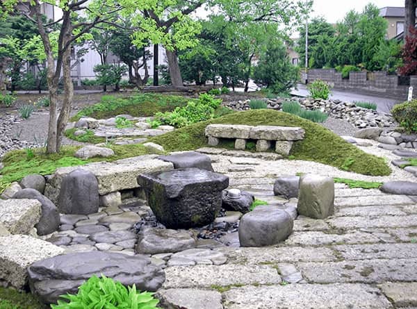 土中から出た石、既存の玉石と米搗き臼で作った水が湧く「縁側」テラス