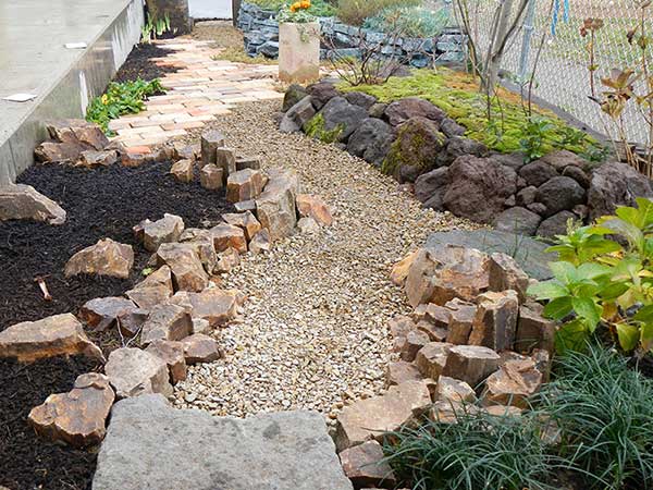 「橙」「赤」「青」の石を積み花壇