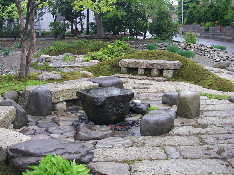 自噴式の石臼のある石のテラス