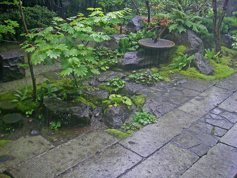 自然石の石張りが直線的な大谷石の中に道を作る