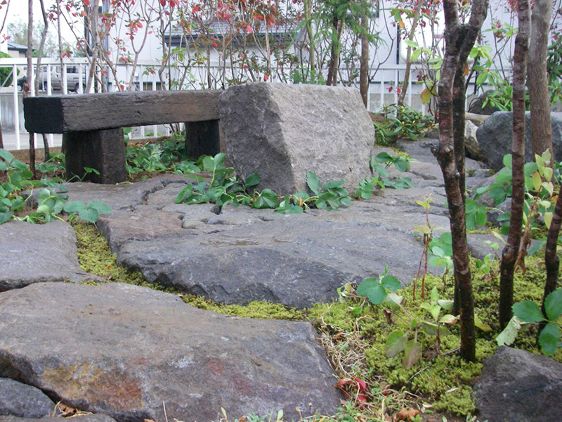 枕木のベンチとイチゴが茂る石のテーブル