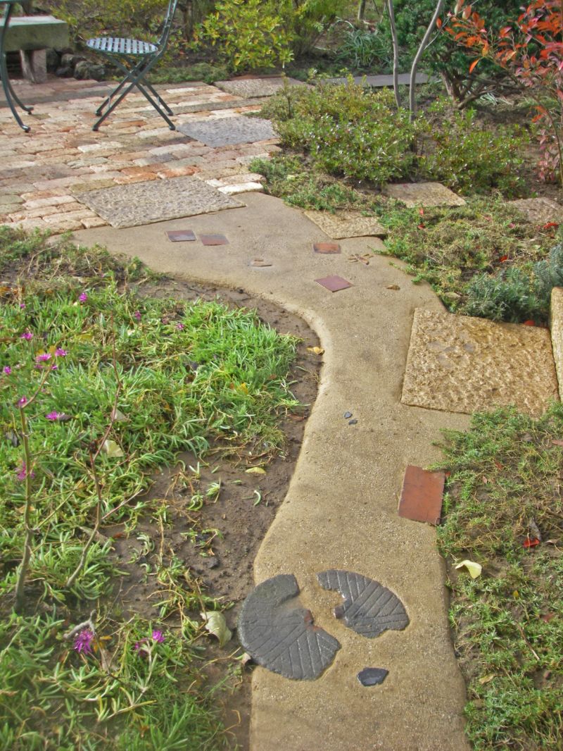 レンガや石臼を入れた三和土の小道