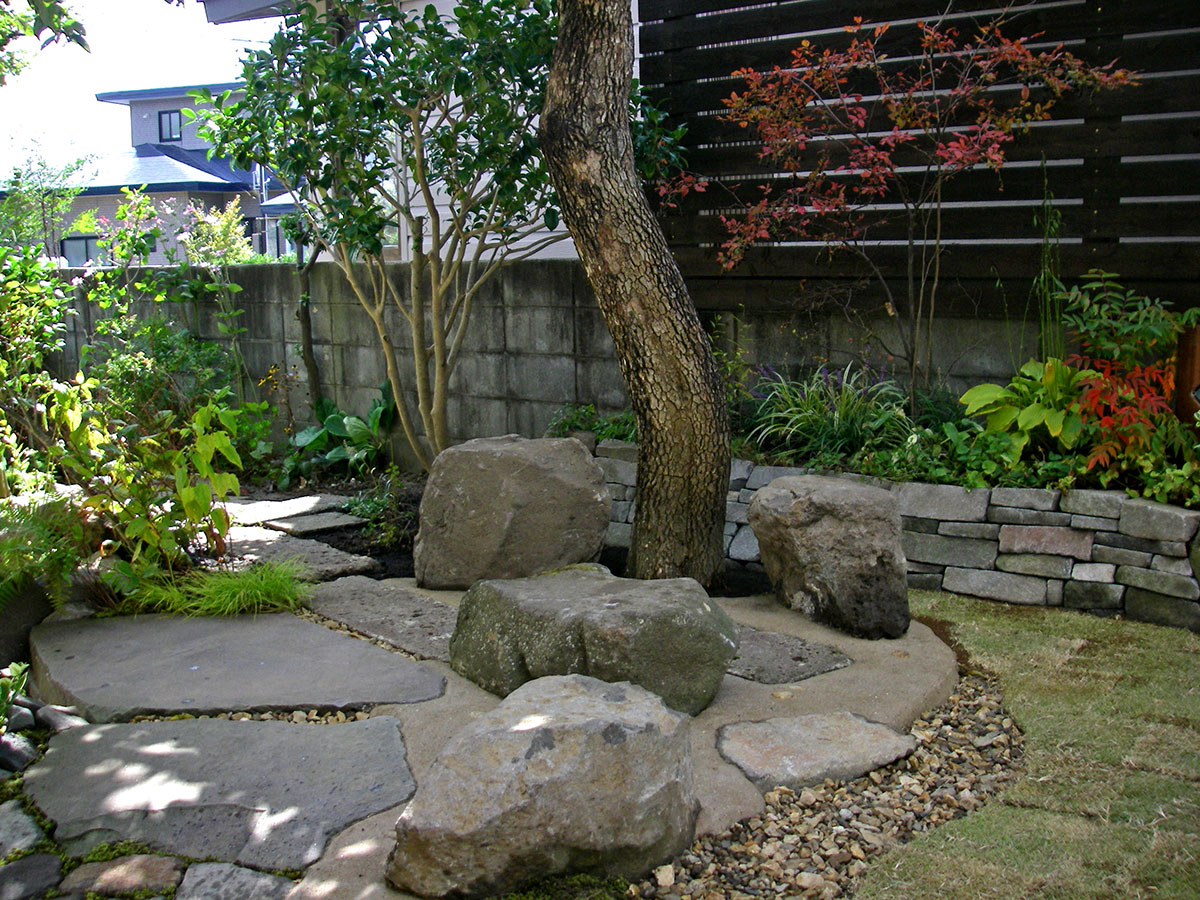 テラスの後ろから広がる石積み花壇